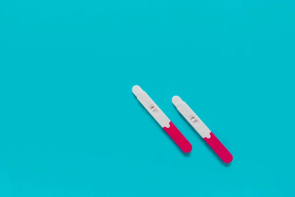 positive and negative pregnancy tests on blue background