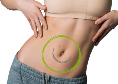 Kadının vücudu mükemmel durumda ve göbeğinde yeşil ve gri bir gülümseme var. Sağlıklı gıda konsepti. Beyaz arkaplanda izole.