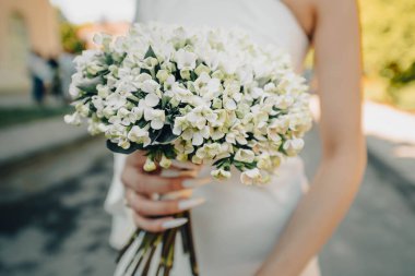 Gelinin ellerinde bir buket yasemin çiçeği.