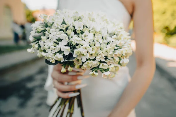 Gelinin ellerinde bir buket yasemin çiçeği.