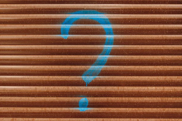 drawn blue question mark on the background of the fence