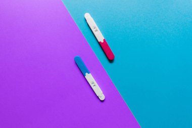 Mavi ve mor arkaplanlar üzerinde pozitif ve negatif hamilelik testleri