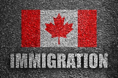 IMMIGRATION and flag of Canada on asphalt road