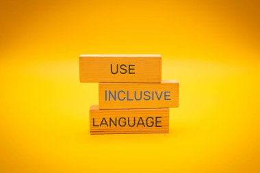 USE INCLUSIVE ENGLISH text written on wood block yellow background