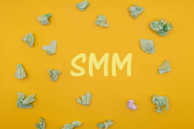 Sarı arka planda buruşmuş kağıt topları. Üst görünüm smm metni. Asgari smm konsepti