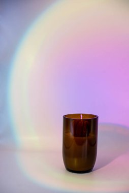 Kehribar camlı soya mumu pembe gradyan arka planda.