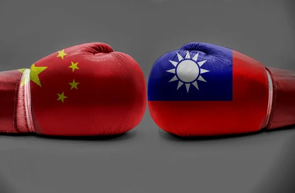 Flags of Taiwan and China on boxing gloves on gray background. Taiwan vs China in World political war concept