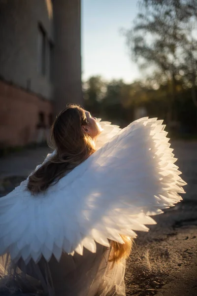 太陽の光は天使の翼を持つ若い美しいブロンドの女の子の顔に落ちる 肖像画 — ストック写真