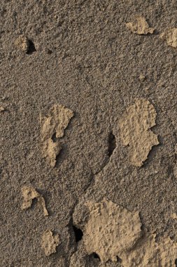 old wall with crumbling and ruined yellow plaster, perpendicular view