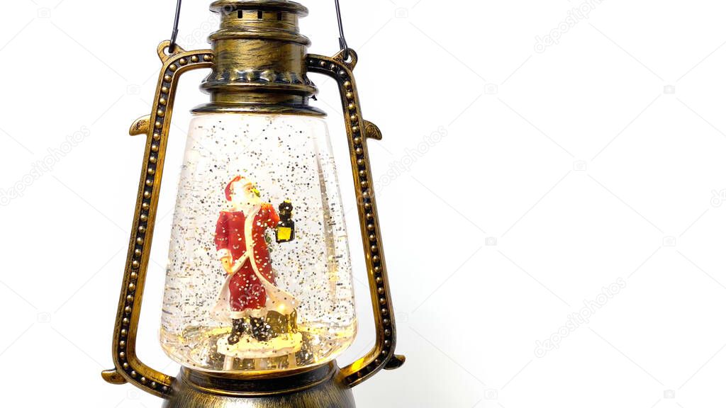 Christmas magic lantern with toy Santa on white background. Holiday composition. Copy space.