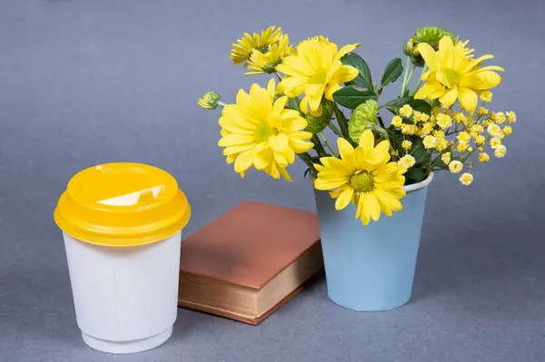 Желтые Цветы Белая Бумага Чашка Кофе Книга Сером Фоне — стоковое фото