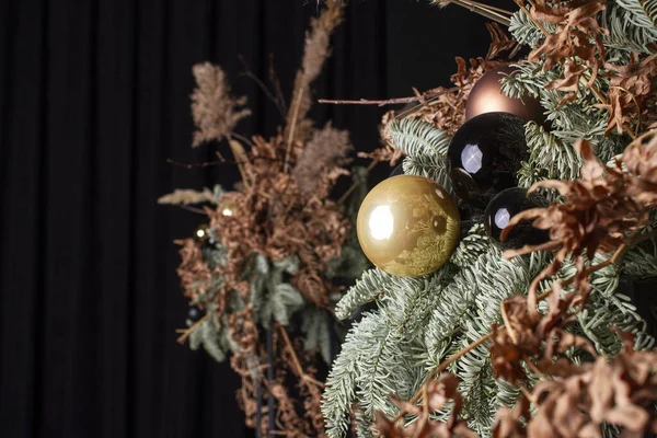 Toplar ve çelenklerle süslenmiş modern tasarım Noel ağacı. Kış tatilleri kompozisyonu.