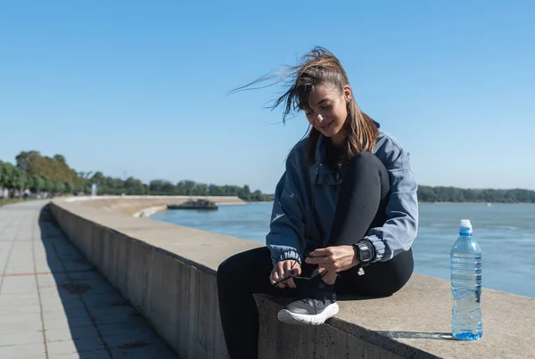 Young happy fitness runner woman tying her shoes prepare for run and jogging outdoor on the sunny weather for healthy life with healthy mind