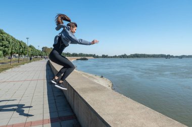 Genç, aktif, terli, kaslı, formda bir kadın spor salonunda egzersiz yapmak için duvarda atlıyor. Gerçek insanlar egzersiz yapıyor, hareket bulanıklığı var.