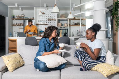 İki genç kadın kanepede oturup çay ya da kahve içerken kadın sorunlarından bahsederken erkekler mutfakta durup onlara yemek pişirirken dizüstü bilgisayardan yemek tarifi okuyorlar. 