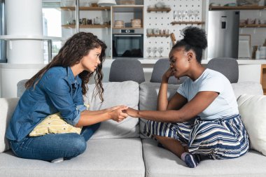 Young woman comforting and hearing out her upset sad friend who has broke up with her boyfriend and she feeling sad and abandoned after long relationship clipart