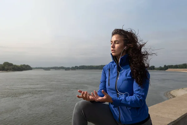 Young happy carefree self-loved and self-aware yoga fitness woman is active and practices yoga outside on a sunny autumn morning. Runner woman practice breathing outdoor before running sport exercise.