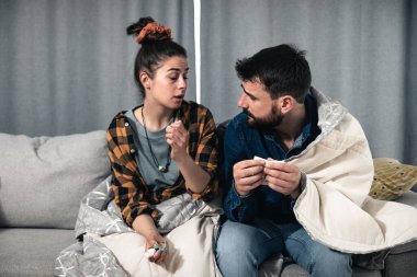 Hasta adam ve kadın nezle, grip ve yüksek ateş. Hasta genç çift yüksek ateş ve burun akıntısı ile boğaz ağrısı ile boğuşuyor.. 