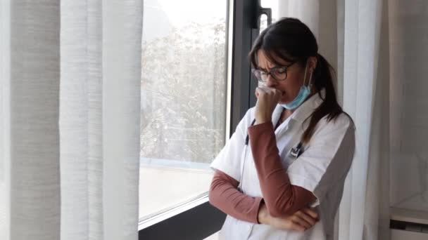 Joven Mujer Triste Médico Tomando Descanso Pie Mirando Través Ventana — Vídeo de stock