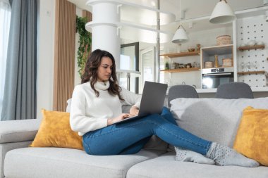 Genç kadın serbest yazılım ve web geliştirici programcı evden dizüstü bilgisayarla çalışıyor. Kadın iş adamı internet üzerinden ödeme yapan ve rezervasyon yapan müşteriler için yeni bilgisayar ve cep telefonu uygulaması geliştiriyor.