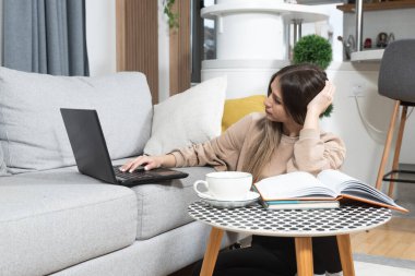 Genç kadın serbest yazılım ve web geliştirici programcı evden dizüstü bilgisayarla çalışıyor. Kadın iş adamı internet üzerinden ödeme yapan ve rezervasyon yapan müşteriler için yeni bilgisayar ve cep telefonu uygulaması geliştiriyor.