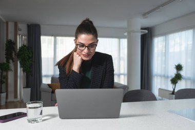 Genç kadın serbest yazılım ve web geliştirici programcı evden dizüstü bilgisayarla çalışıyor. Kadın iş adamı internet üzerinden ödeme yapan ve rezervasyon yapan müşteriler için yeni bilgisayar ve cep telefonu uygulaması geliştiriyor.
