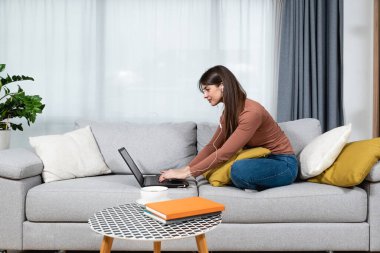 Genç hasta üniversiteli kadın evde oturup bilgisayarındaki video konferans görüşmesi için çevrimiçi derse hazırlanıyor. Çevrimiçi internet iş eğitimi, sağlık konsepti.