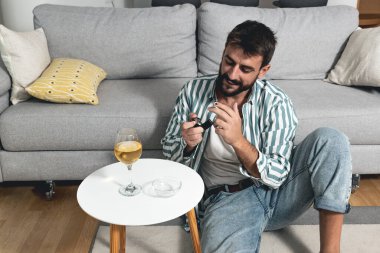 Genç kaygısız bir adam evinde yerde oturmuş sigara yakıyor ve şarap içiyor. Artık mutsuz ve bunalımlı olmamaya karar verdi. Çünkü hayat sadece bir ve yaşamak istiyor.