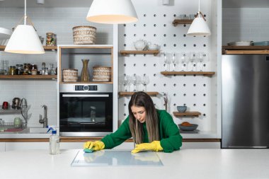 Genç ev sahibi kiraya verdiği daire için büyük bir temizlik yapıyor. Kiraladığı yeni kiracıların temizlenmesi için. Genç kız ya da kadın mutfağı ovuyor..