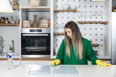Genç ev sahibi kiraya verdiği daire için büyük bir temizlik yapıyor. Kiraladığı yeni kiracıların temizlenmesi için. Genç kız ya da kadın mutfağı ovuyor..