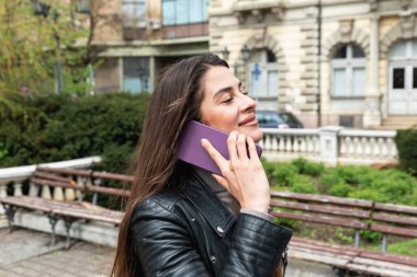 Deri ceketli ve güneş gözlüklü genç bir kadın ofis binasının önünde erkek arkadaşını bekliyor ve rock konserine gidebilmeleri için ona mesaj ya da çağrı yolluyor..
