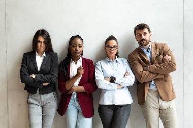 Uzmanların portresi. Ofiste kolları bağlı duran iş adamları. Ofis binasında kendine güveni olan başarılı iş arkadaşları..