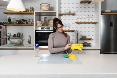 Genç ev sahibi kiraya verdiği daire için büyük bir temizlik yapıyor. Kiraladığı yeni kiracıların temizlenmesi için. Genç kız ya da kadın mutfağı ovuyor..