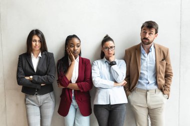 Bir grup başarılı iş adamı ofis binasında duruyor. Proje çözümleri hakkında düşünen serbest çalışan uzmanlar ve meslektaşlar. 