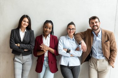 Bir grup başarılı iş adamı ofis binasında duruyor. Proje çözümleri hakkında düşünen serbest çalışan uzmanlar ve meslektaşlar. 