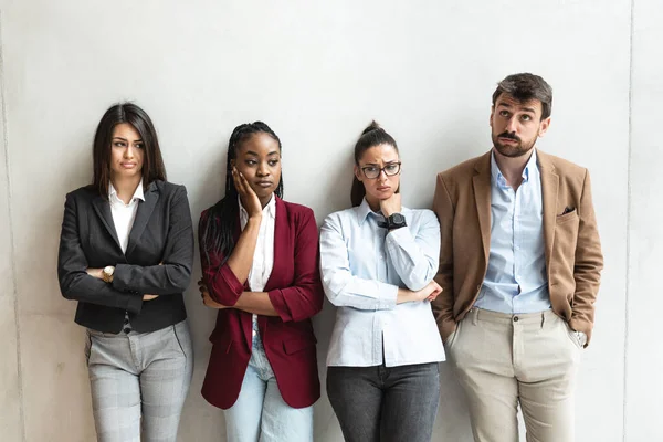 Bir grup başarılı iş adamı ofis binasında duruyor. Proje çözümleri hakkında düşünen serbest çalışan uzmanlar ve meslektaşlar. 