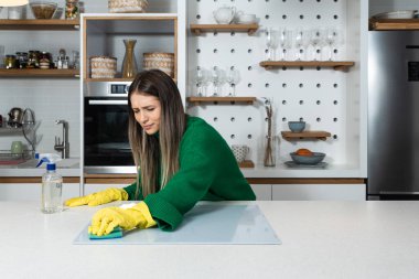 Genç ev sahibi kadın kiraya verdiği daire için büyük bir temizlik yapıyor. Kiraladığı yeni kiracılar için temiz olmak için. Genç bir kız ya da kadın evini ovuyor..