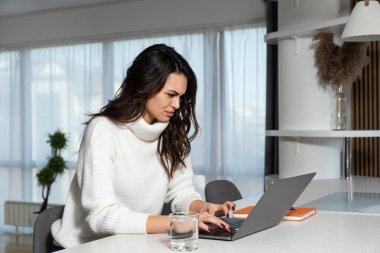 Genç kadın serbest yazılım ve web geliştirici programcı evden dizüstü bilgisayarla çalışıyor. Kadın iş adamı internet üzerinden ödeme yapan ve rezervasyon yapan müşteriler için yeni bilgisayar ve cep telefonu uygulaması geliştiriyor.