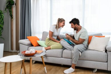 Young happy couple man and woman celebrate after she had pregnancy test and test is positive. Pregnant girl hugging her boyfriend from happiness after she find out that they will have a baby.