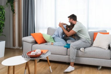 Young happy couple man and woman celebrate after she had pregnancy test and test is positive. Pregnant girl hugging her boyfriend from happiness after she find out that they will have a baby.