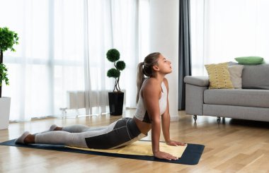 Young woman rehabilitation exercise at home after car crash accident. Recovery workout of young girl with yoga training poses for stretching the muscles. Female after childbirth relaxing.