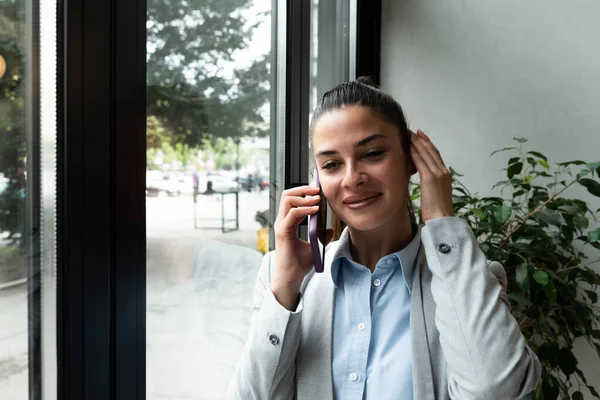 Young woman successful real estate agent making appointment with potential client who is interested for apartment to rent. Rental agency worker selling over the phone home to a buyer.
