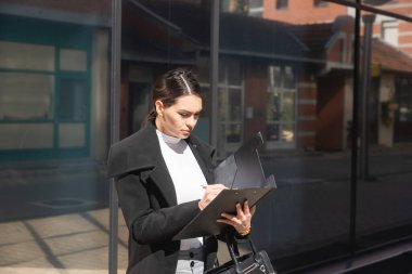 Young woman successful real estate agent making appointment with potential client who is interested for apartment to rent. Rental agency worker selling over the phone home to a buyer.