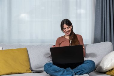 Young woman high school professor or elementary school teacher having online classes with her students from her home. Private lessons on online education video call on laptop computer.