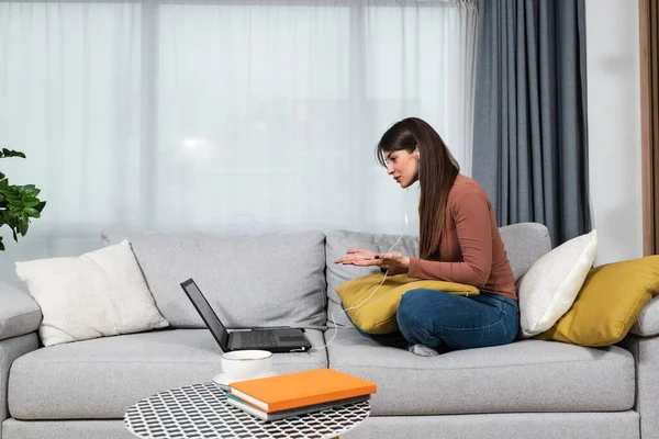 Young woman high school professor or elementary school teacher having online classes with her students from her home. Private lessons on online education video call on laptop computer.