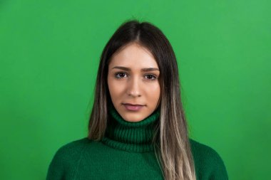 Young beautiful woman or girl model posing in front of green screen background. Portrait of a female with chroma key background.