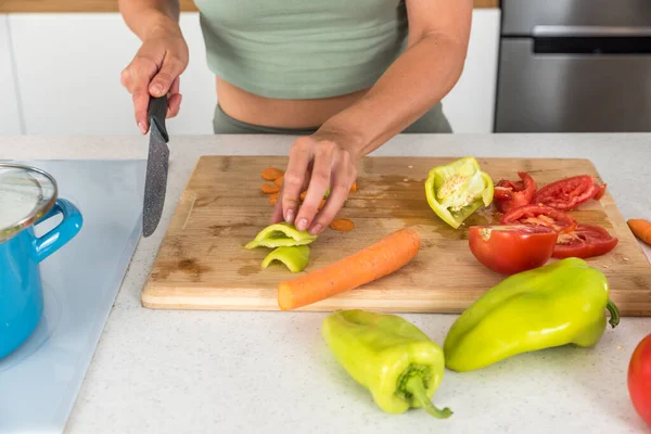 Young woman cancer survivor cooking and preparing vegetarian meal after long heavy sickness. Vegan female in the kitchen making healthy lunch from fresh vegetables changing way of life after illness.