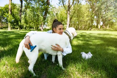 Genç bir kadın, hayvan kurtarma merkezinden Labrador Retriever adlı köpeği evlat edindi ve ona sevgi ve dostluk verdi. Dişi hayvan sever köpek yavrusuyla parkta vakit geçiriyor..