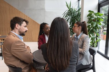 İnternet uygulaması olarak alışveriş rezervasyonu ve restoran rezervasyonu için online iş yapan dört genç insan. Arkadaşlar yeni küçük şirketleri için planlar ve fikirler üzerinde çalışıyorlar..