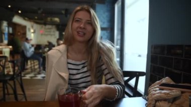 POV erkek arkadaşı, kafeteryada oturmuş çay içip sohbet ederken kız arkadaşını videoya kaydediyor. Konuşurken güzel bir kadın çekiyor ve gülümsüyor..